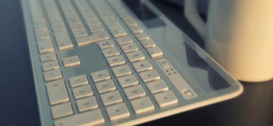 Klawiatura bezprzewodowa na blacie biurka.